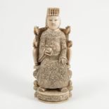 A 19th century carved Oriental model, of a seated figure holding a fruit in their hand,