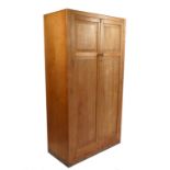 An oak double door wardrobe, with two twin panelled doors opening to reveal a part fitted interior,