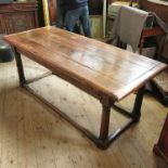 An antique oak refectory table, having a four plank cleated top raised on four gun barrel legs,