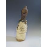 A Liberian Mano or Geh Carved Wooden Figure wrapped in cloth with beads, shells and coins and with