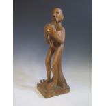 A 1960's Carved African Figure holding a decapitated head while standing on the body , 45.5 cm