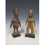 A Pair of Central African Carved Wooden Figures decorated with beads and standing on later bases, c.