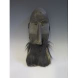 An East Liberia Poro Society Bearded Mask with moveable tongue and spiral iron nail to forehead,