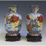 A Pair of Chinese Cloisonné Vases decorated with flowers, on carved wooden bases, 25 cm