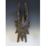 An Ivory Coast Senufu Funeral Mask, used in ceremony and still covered in mud to back, 43 cm. Bought