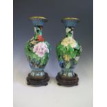 A Pair of Chinese Cloisonné Vases decorated with flowers, on carved wooden bases, 36 cm