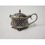 An Edward VII Silver Mustard decorated with pierced scrolling foliate and scrolls and with a blue