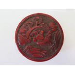 An Antique Chinese Cinnabar Box decorated with figures in landscape, 10 cm diam.