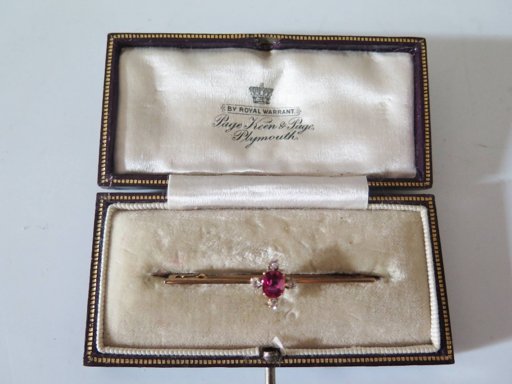 A Ruby and Diamond Bar Brooch in a 9ct yellow gold setting, boxed