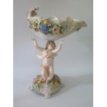 A Continental Porcelain Table Centrepiece in the form of a putti bearing floral encrusted shell