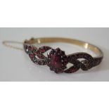 A Garnet Hinged Bracelet in a precious yellow metal setting, 12.3 g