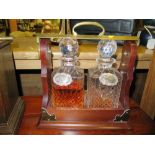 A Two Bottle Mahogany Tantalus with silver labels, NO KEY