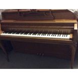 Wurlitzer (c1964) An upright piano in a spinet style walnut case.