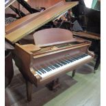 Kemble A 5ft grand piano in an oak case on square tapered legs.