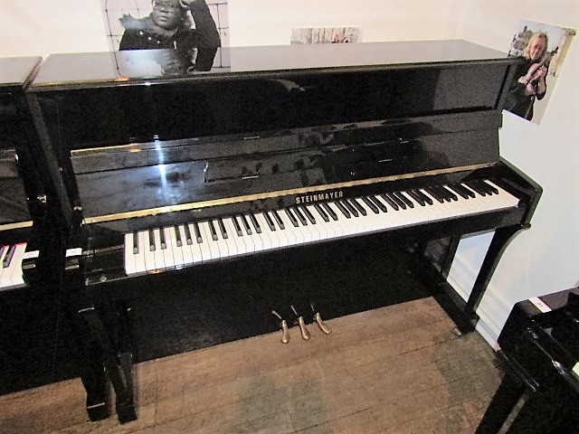 Steinmayer A recent upright piano in a bright ebonised traditional style case;