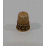 A yellow metal thimble, with a lattice decoration and a stylised foliate band, 2.2cm high, 6.