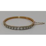 A diamond set hinged gold bangle,