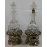 A pair of cut glass decanters with silver plated stands,