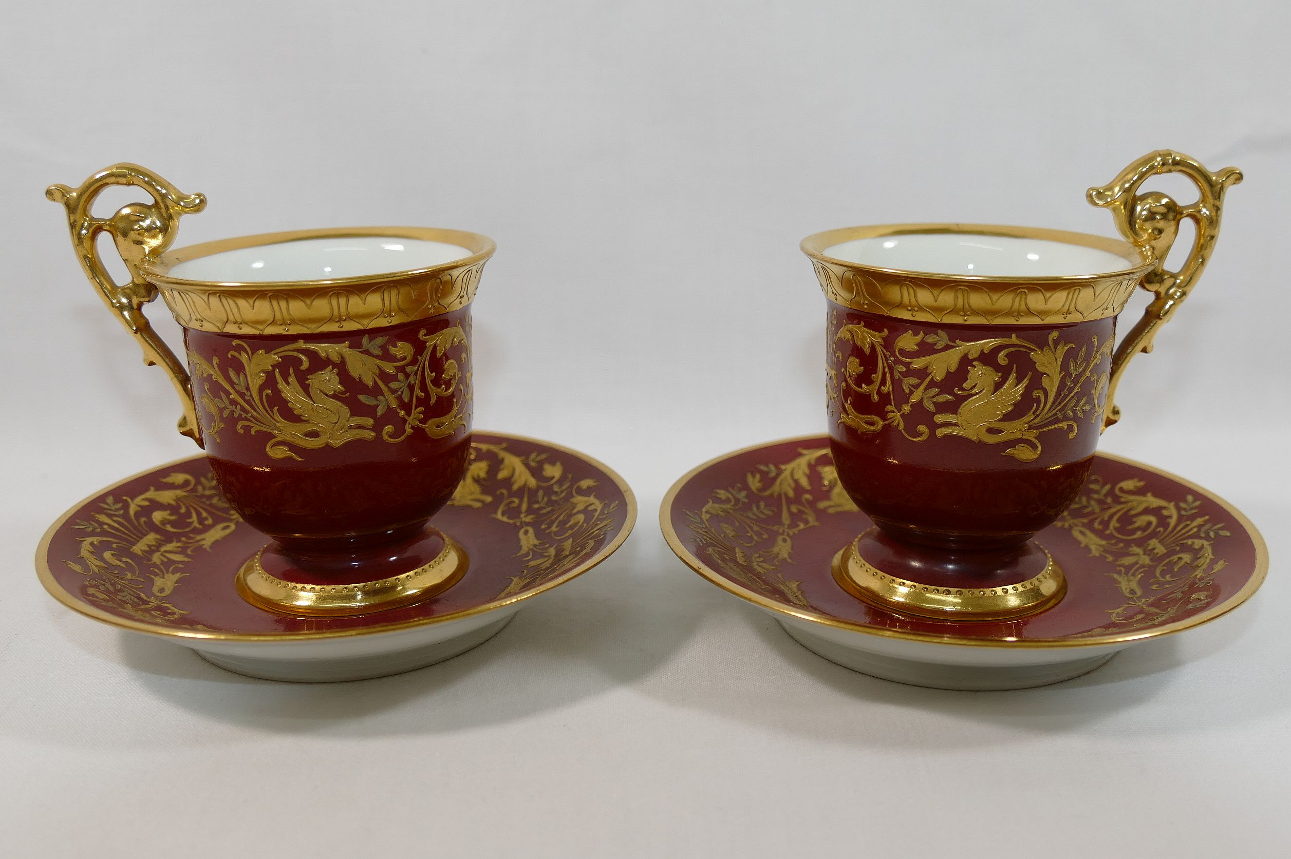 A pair of early 20th century Dresden coffee cups and saucers,