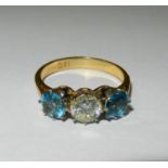 A blue topaz and diamond three stone ring, the round brilliant cut diamond approximately 0.