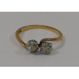 A diamond two-stone cross over ring, the old round brilliant cut stones each approximately 0.