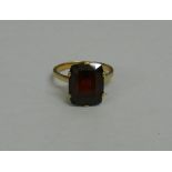 A garnet single stone yellow metal ring, the cushion shaped mixed cut stone, 13mm x 11mm,