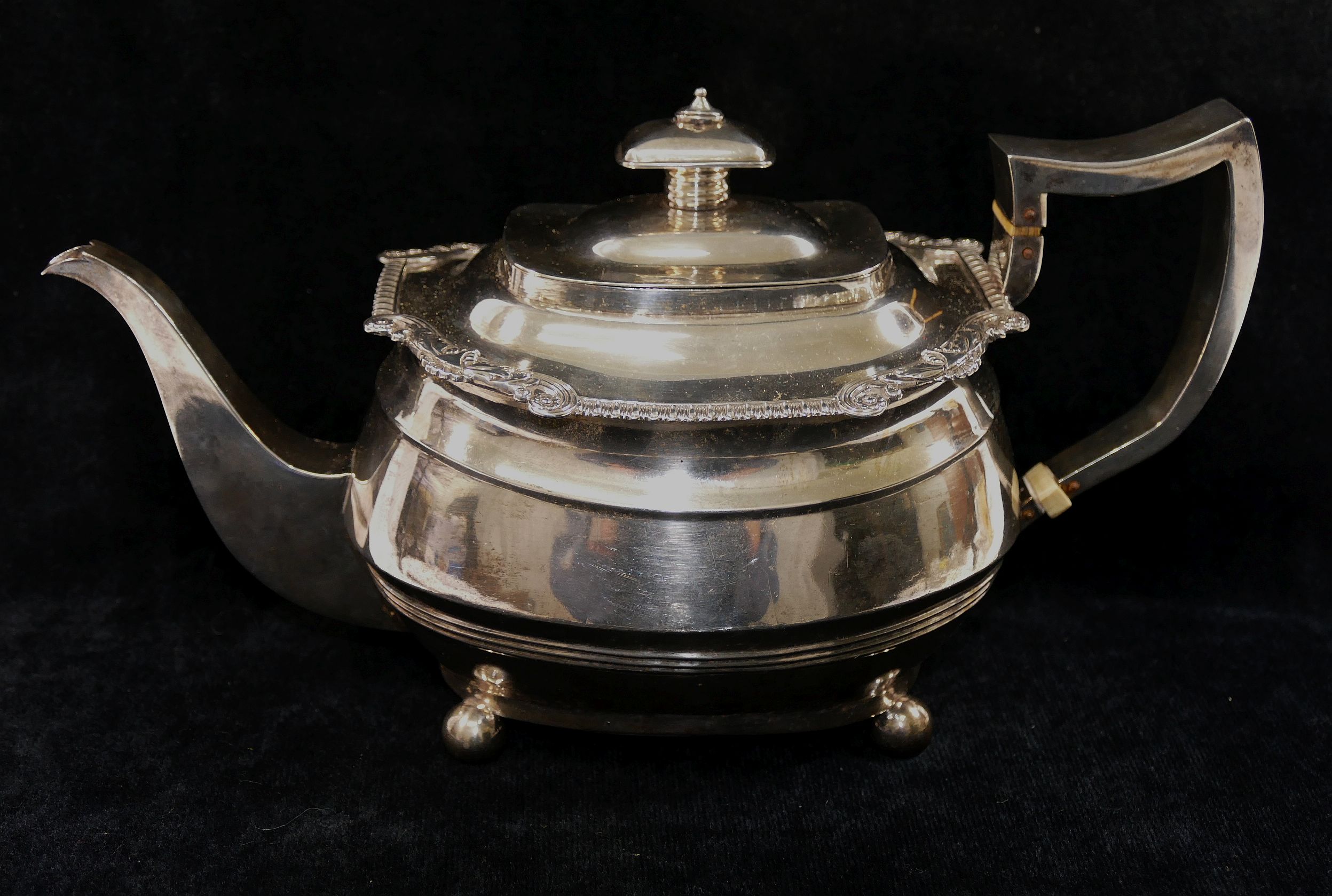 A George III silver teapot, London 1814, the body with reeded band, the rim with scroll,