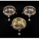 A pair of George II circular silver salts, London 1735, raised on three hoof feet with wavy rims, 3.