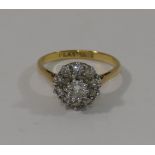 A yellow metal diamond cluster ring, the centre round brilliant cut diamond approximately 0.