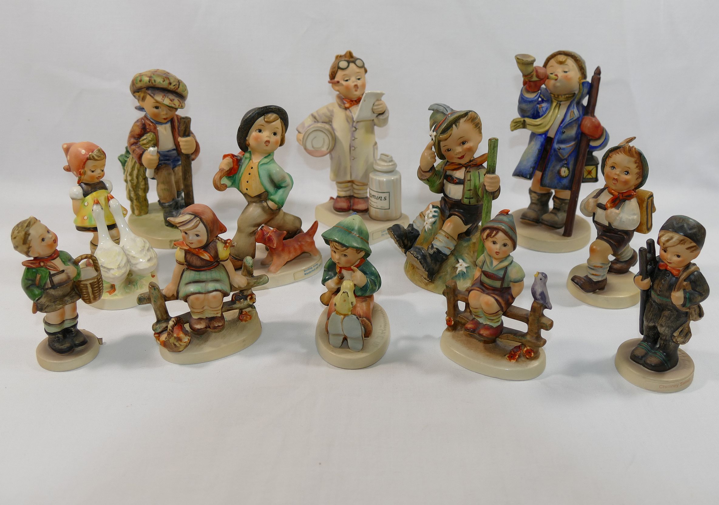 Twelve Goebel figures by M J Hummel, including the 'Little Pharmacist', 4.