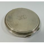 A silver circular compact, Birmingham 1960, with engine turned deocration, 7.8cm diameter, 3.