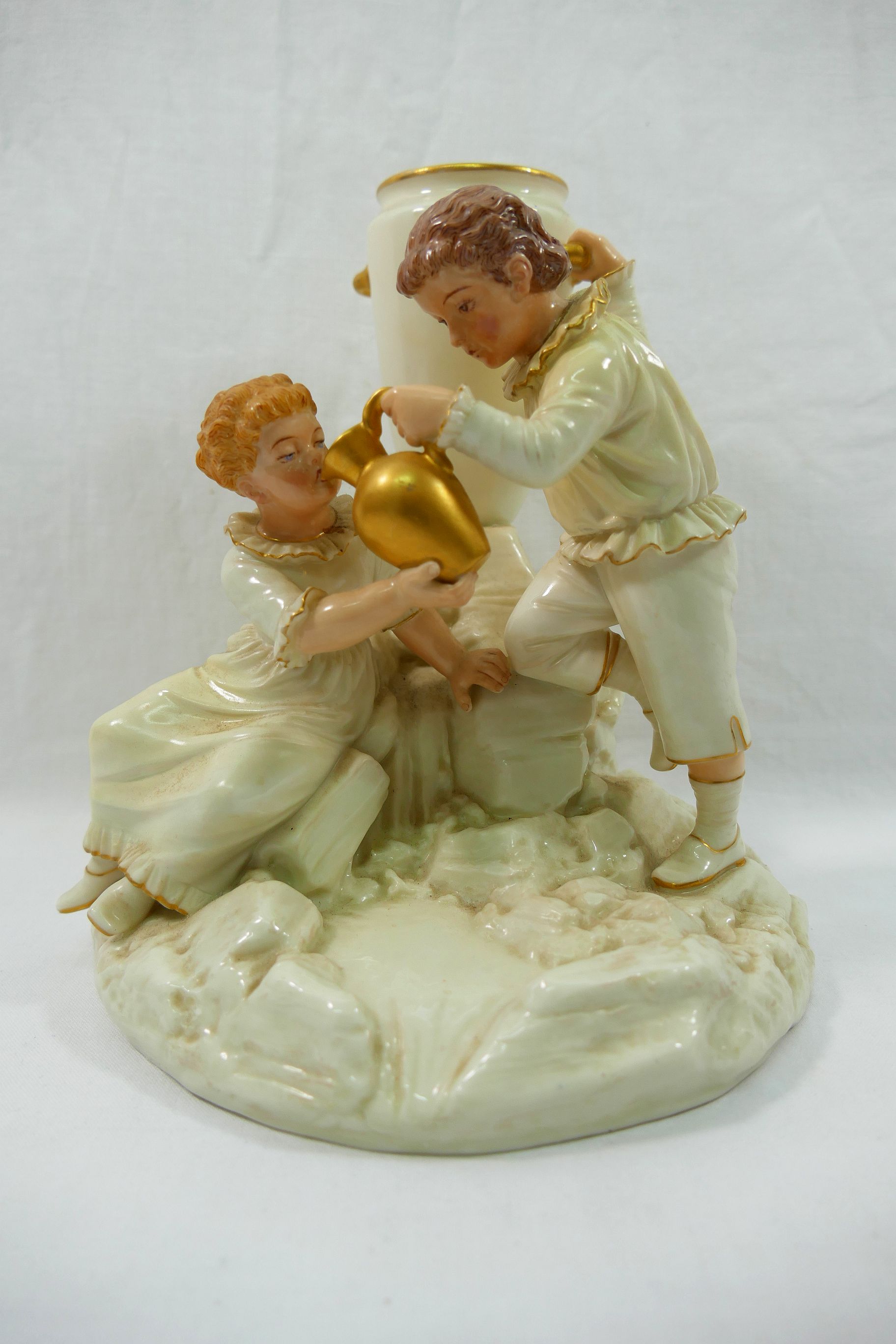 A Royal Worcester porcelain figural spill holder by James Hadley modelled as a boy and a girl