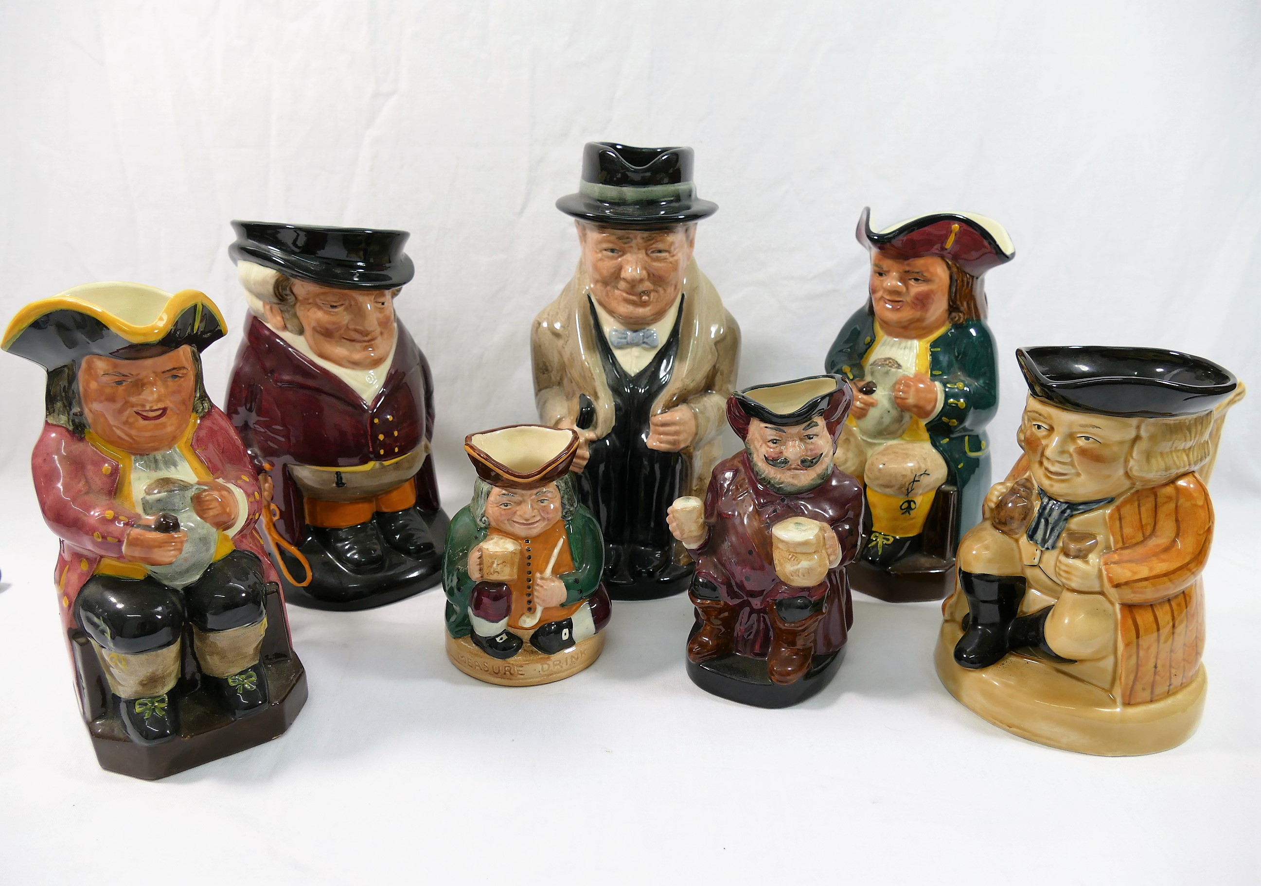 Four Royal Doulton charactar jugs comprised of 'The Huntsman', 18cm high, 'Winston Churchill', 22.