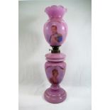 A Victorian pink glass oil lamp hand painted with portraits of Queen Victoria and Prince Albert,