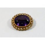 An oval amethyst and seed pearl brooch, stamped '15CT',