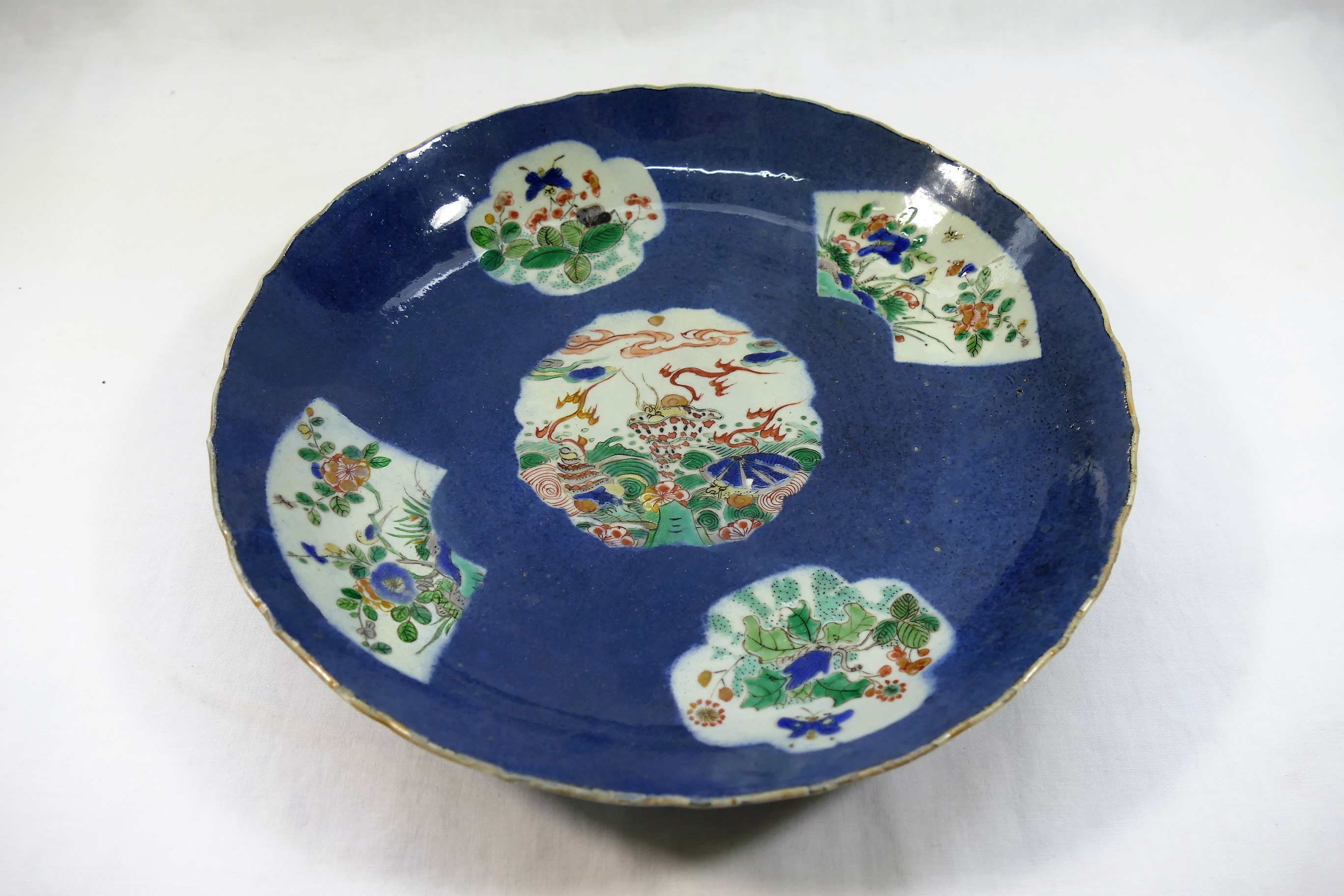 A Chinese famille vert blue ground dish, the centre panel decorated with shellfish,