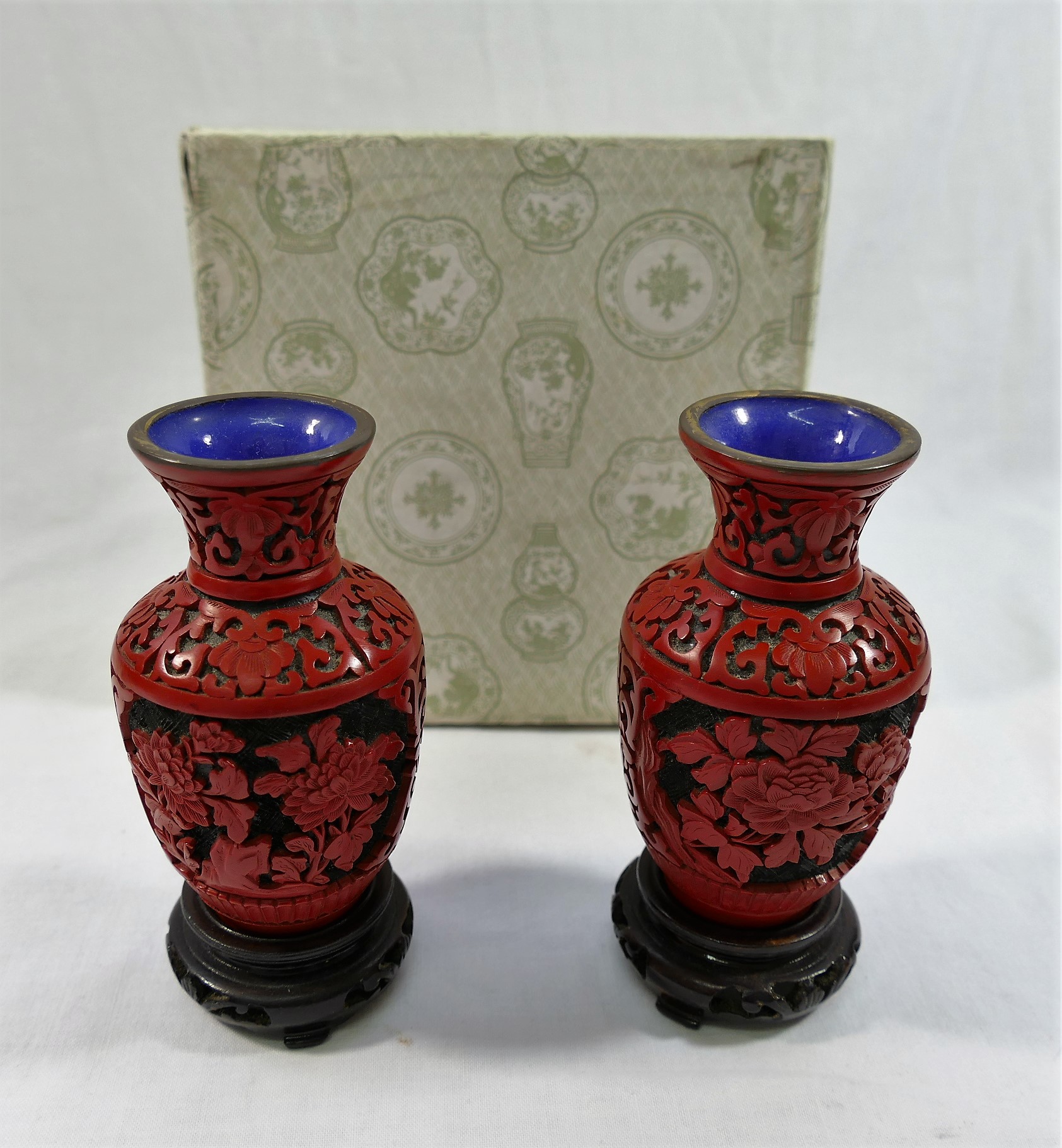 A pair of small red cinnabar lacquer vases, pierced and carved with floral panels,