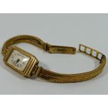 A 9 carat gold cased ladies bracelet watch, the rectangular white enamel face with Arabic numerals,