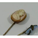 A Victorian gold mounted carved shell cameo topped stick pin and a simulated opal topped stick pin