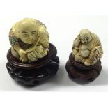 Two carved netsuke's on wood stands.