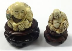 Two carved netsuke's on wood stands.