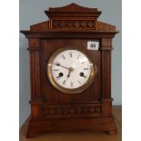 A German oak mantle clock, circular enamelled dial, 8 day movement, with strike on gong, with key