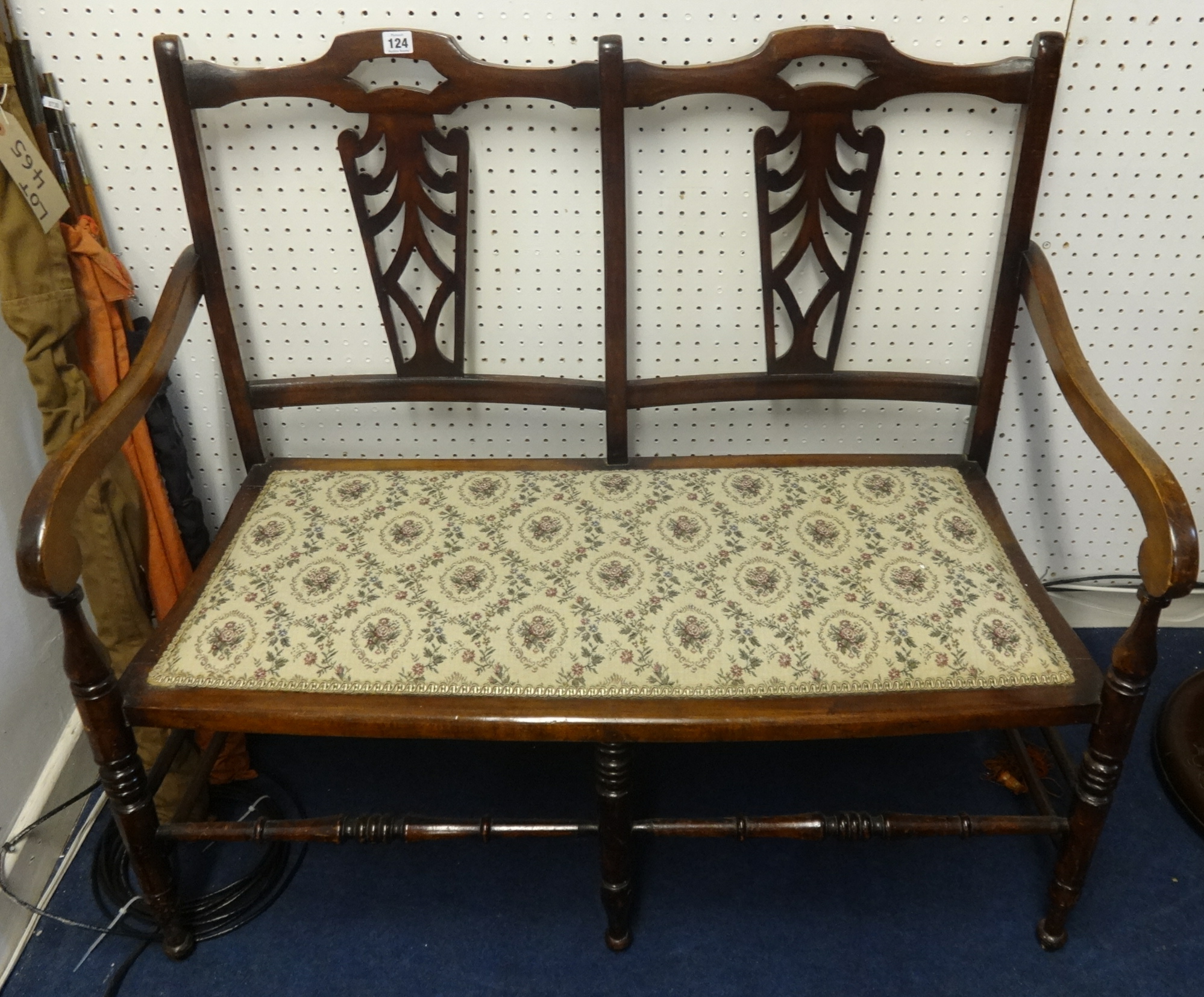 A two seater stained beech wood framed settee.