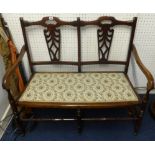 A two seater stained beech wood framed settee.