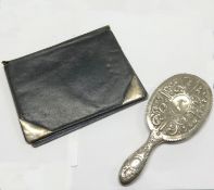 White metal hand mirror and a leather wallet with silver mounts (2).