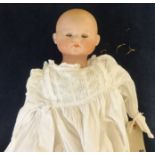 An Armand Marseille / Simon and Halbig bisque head doll (head detached), with straw filled body,