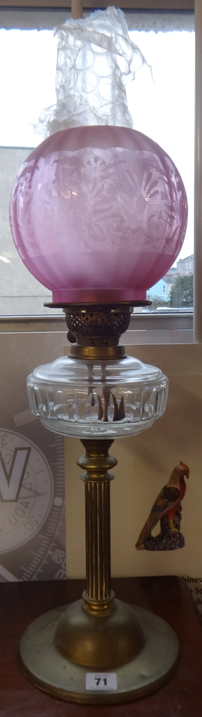 A traditional oil lamp with glass globe shade.