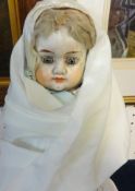An early 20th century German composition doll, blue fixed eyes, closed mouth (with under dress