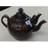 A Victorian pottery treacle glaze double spout tea pot.