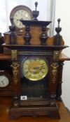 A 19th century German architectural oak case mantle clock with key and pendulum.